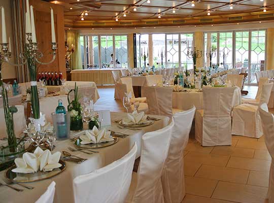 Großer, lichtdurchfluteter Speisesaal des Jägerhofs mit großen Tischen und schöner Tischdekoration.