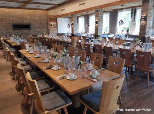 modern, rustikaler Gastraum mit viel Holl und Steinwänden