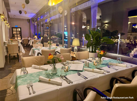 elegant gedeckte Tische vor Glasfront