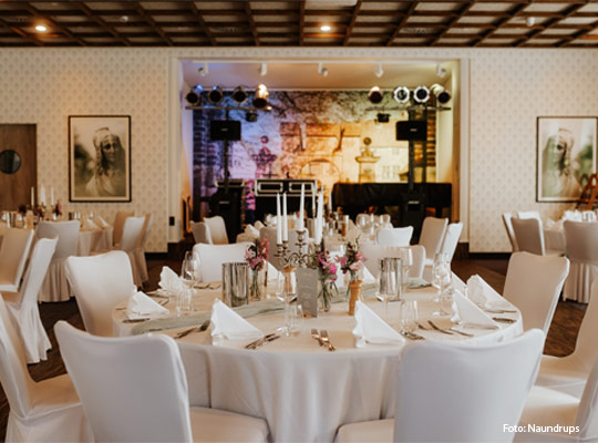 große, festlich eingedeckte Tafel mit großem Kerzenständer