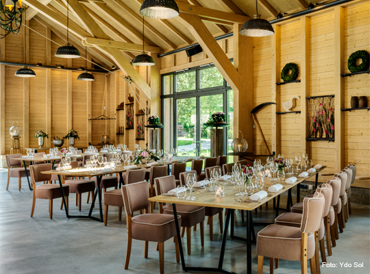 lange gedeckte Tische in der großzügigen und hellen Festscheune