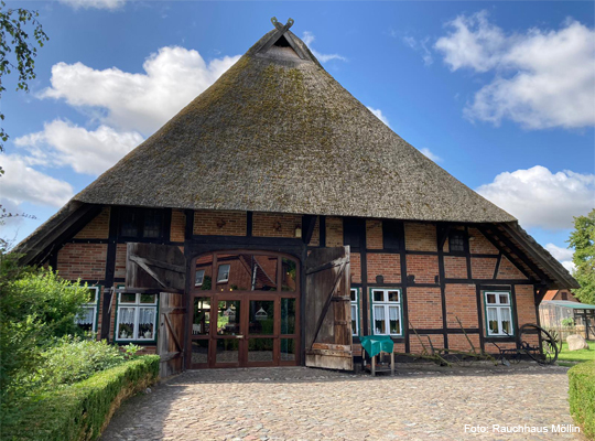 Außenansicht vom Rauchhaus Möllin mit Strohdach