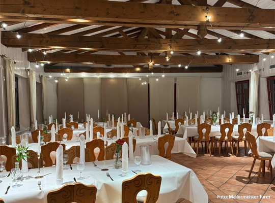 elegant eingedeckter Speisesaal mit sichtbarem Gebälk