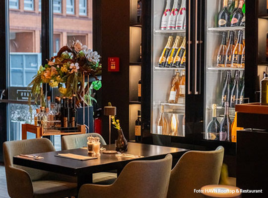 beleuchteter Weinkühlschrank mit schönem Blumenbouquet daneben