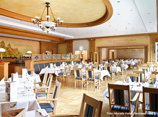 schöner Gastraum mit viel hellem Holz und Wandmalerei