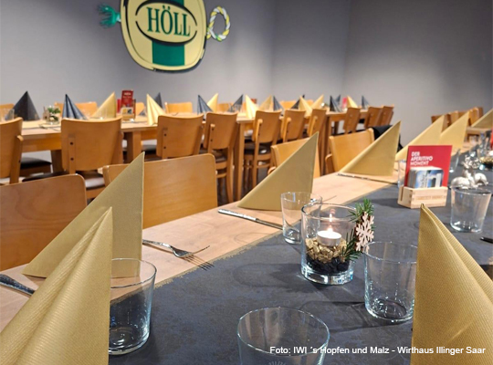 eingedeckte Tische im schlicht gehaltenen Veranstaltungssaal