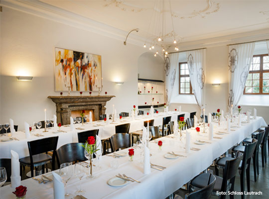 elegant gedeckte Tafeln im Speisesaal mit hoher Stuckdecke