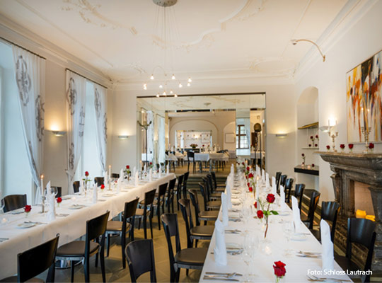 stilvoll, in weiß gedeckte Speisetafeln mit roten Rosen auf den Tafeln