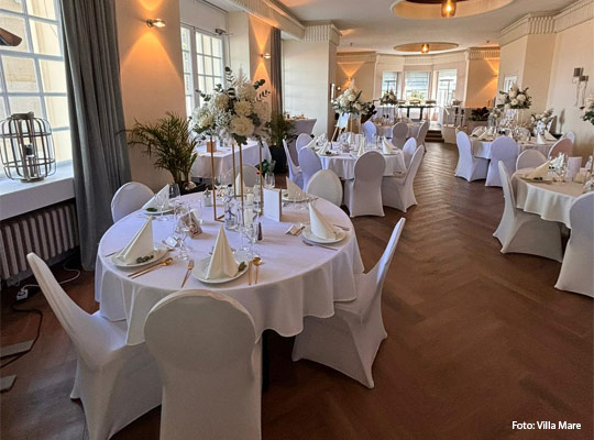 elegant eingedeckter Saal mit runden Tischen