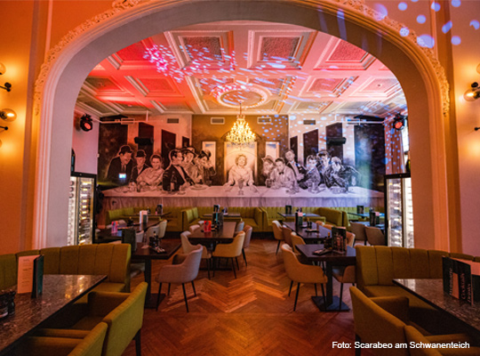 toll beleuchteter, außergewöhnlicher Gastraum mit großem Wandbild