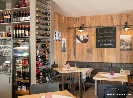 Weinpräsentation in Wandregal und Kühlschrank im Gastraum