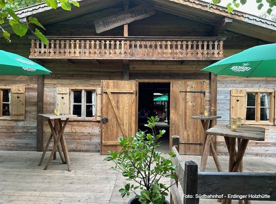 Frontansicht der Holzhütte mit Außengastronomie