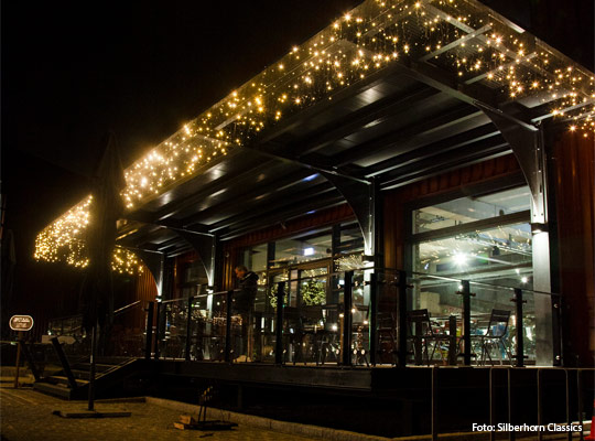 Außenansicht bei Nacht mit beleuchteter Glasfront