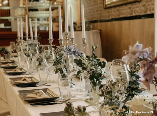 elegant gedeckter Tisch mit Blumenarrangements und Kerzenständern