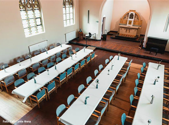 lange, festlich gedeckte Tafeln in Kulturkapelle