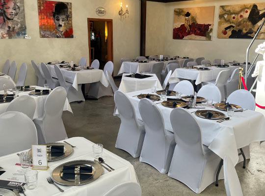 Saal mit gedeckten Tischen im Hotel Amical