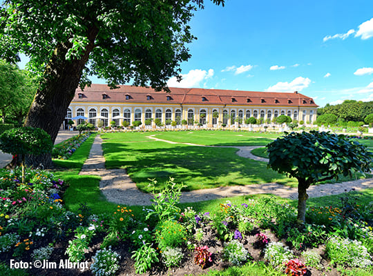 Blick auf das schöne Gebäude des Orangerie Ansbach mit dem riesigen Hofgarten Ansbach im Vordergrund