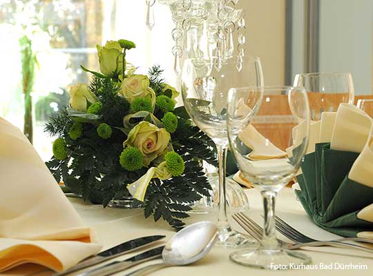 Mit schönen Blumen gedeckter Tisch für das Dinnerkrimi