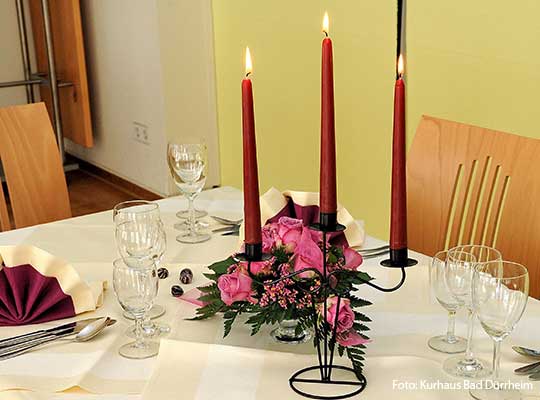 Liebevoll dekorierter Tisch mit Kerzenständer und weißer Tischdecke für das Dinnerkrimi