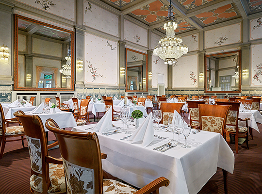 Nobel gestalteter Speisesaal mit hochwertigen Stühlen und herzlichst dekorierten Tischen im Rahmen des Dinnerkrimi