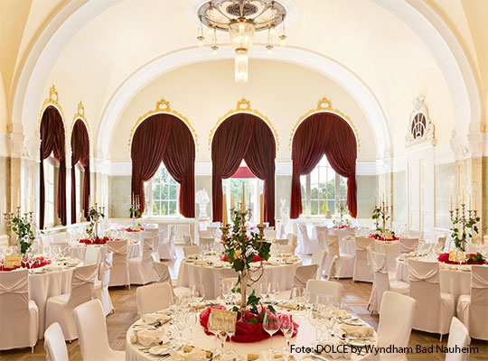 Schöner, großer Saal mit weiß gedeckten Tischen 