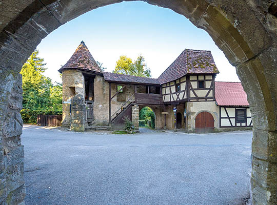 Blick in den Burginnenhof durch ein Rundbogentor.