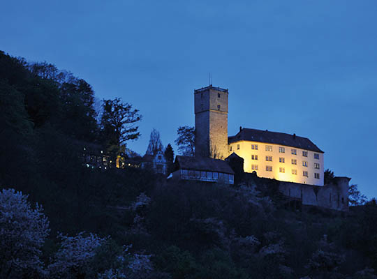 Hellbeleuchtete Burg Guttenberg in der Nacht.