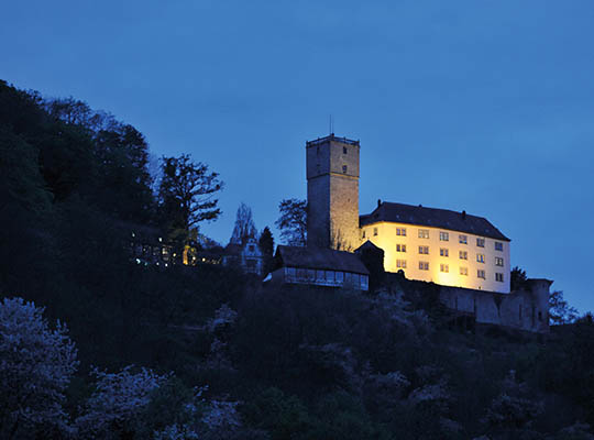 Hellbeleuchtete Burg Guttenberg in der Nacht.