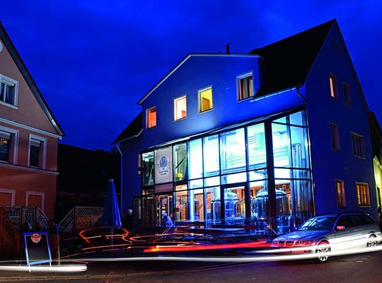 Blau leuchtendes Restaurantgebäude in der Nacht.