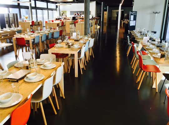 Blick auf den Gang im eingedeckten Saal mit bunten Stühlen beim Krimidinner Bern