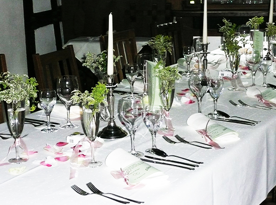 Lange Tischtafel mit weißer Tischdecke und schöner dekoration.
