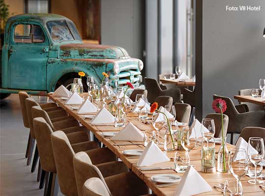 Lange, liebevoll gedeckte Tischtafel mit einem grünen Oldtimer im Hintergrund.