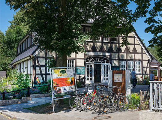 Das große Landhaus inklusive schön grünem Garten im Vordergrund.