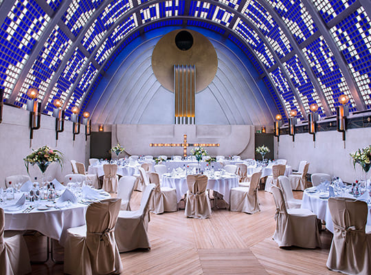 Viele angerichtete sowie schön dekorierte Tischgarnituren im traumhaftschönen großen Himmelsaal mit atemraubend schöner Decke.