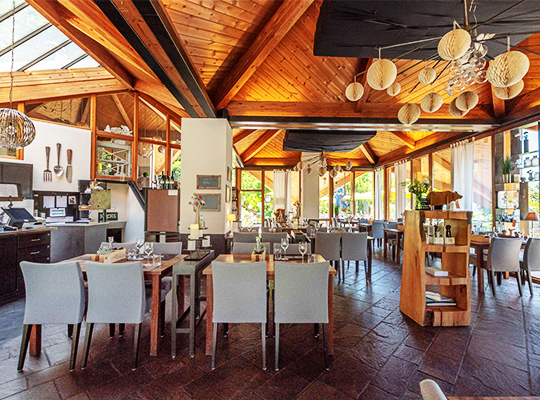 Einzigartig schön dekorierter Speisesaal mit hölzerner Decke und vielen großen Fenster, die für bestes Licht sorgen.