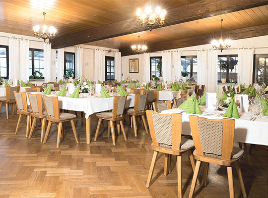 Mit hellen Deckenleuchten beleuchteter Saal mit vielen Tischen, angerichtet für das Dinnerkrimi Coburg