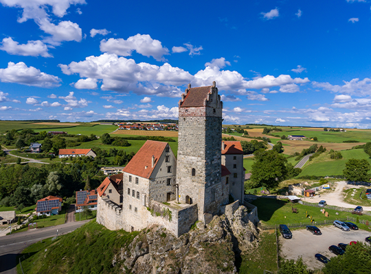 Burg Katzenstein ragt empor vor blauen Himmel und grünen Wiesen