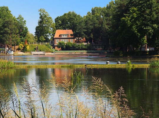 Vor dem schönen, urigen Waldbadhaus liegt ein großer Badesee.