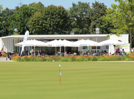 Von der Sonne angestrahlter Golfplatz mit dem schönen Restaurant.9 im Hintergrund