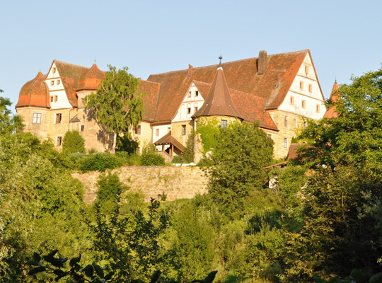 Von der warmen Sonne bestrahltes Schloss Wiesenthau aus der Ferne betrachtet