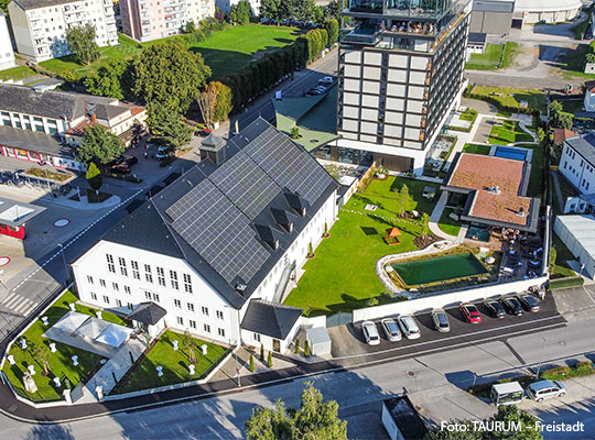 Ein großes Haus mit einer Grünfläche und einem Parkplatz