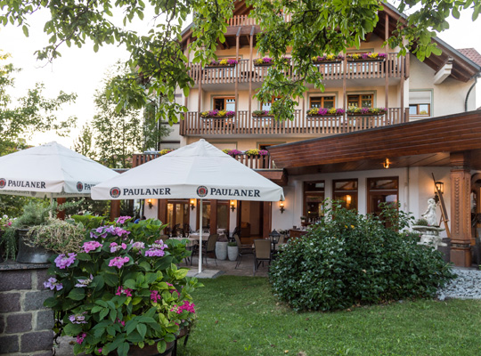 Grün leuchtender Garten vor dem schönen Hotelgebäude