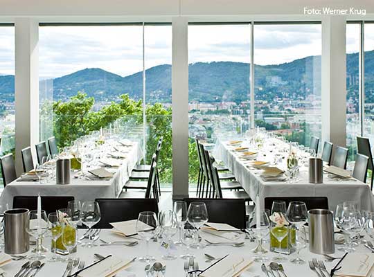 Blick auf den eingedeckten Saal beim Dinnerkrimi mit schöner Tischdeko und Aussicht aus dem Fenster