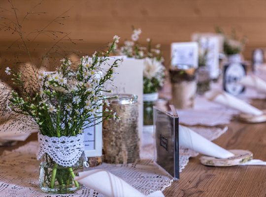Toll gedeckter Tisch mit Blumenvasen, Servietten und Kerzen