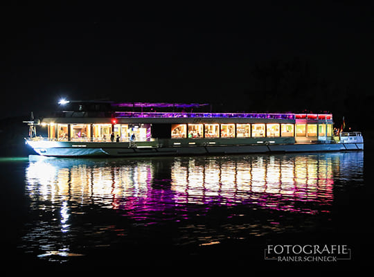 Wundervolle, abendliche Beleuchtung des Schiffes spiegelt sich auf der Wasseroberflache beim Dinnerkrimi Kelheim