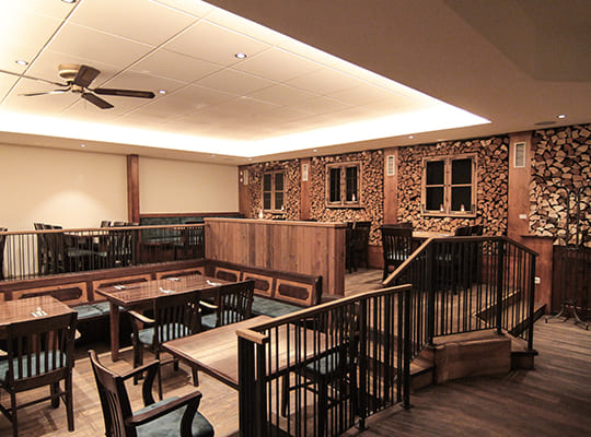 Schön eingerichteter, moderner Restaurantsaal mit leichter Erhöhung und angenehmem Ambientelicht