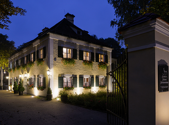 Komplett saniertes historisches Gebäude inklusive schönem Vorhof in heller nächtlicher Beleuchtung