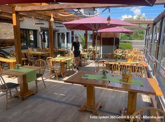 Terrassenbereich mit hölzerner Außengarnitur beim Dinnerkrimi Neuffen