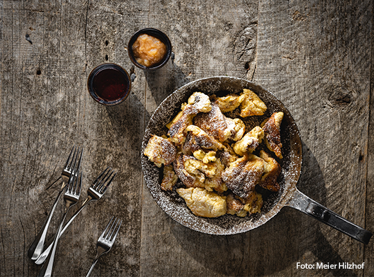 Kaiserscharrn steht in einer Pfanne mit Besteck auf einem Holztisch 