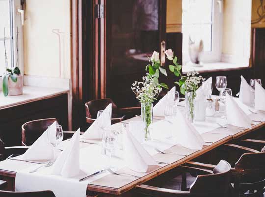 Gedeckter Tisch mit weißen Servietten und Blumen 